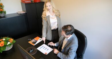 Colleagues discussing documents beside a desk