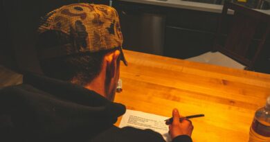 Person writing in a notebook at a wooden desk