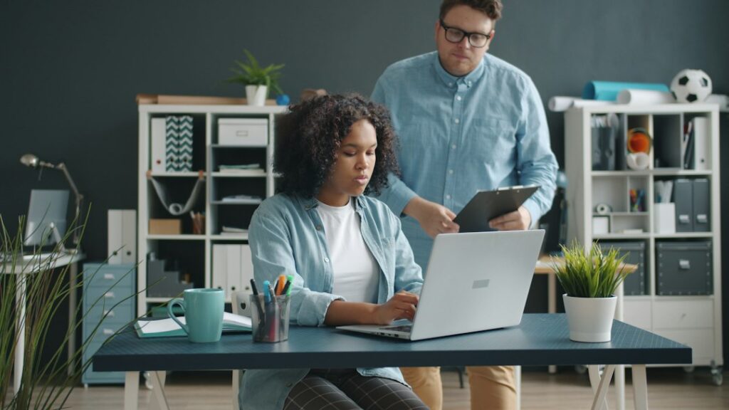 Two colleagues discussing work at a laptop