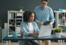 Two colleagues discussing work at a laptop