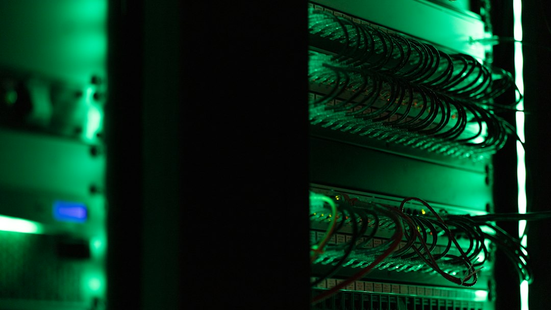 Network equipment and cables in a green-lit server rack