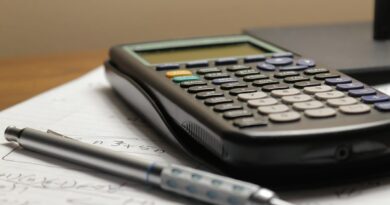 Calculator and pen resting on handwritten notes