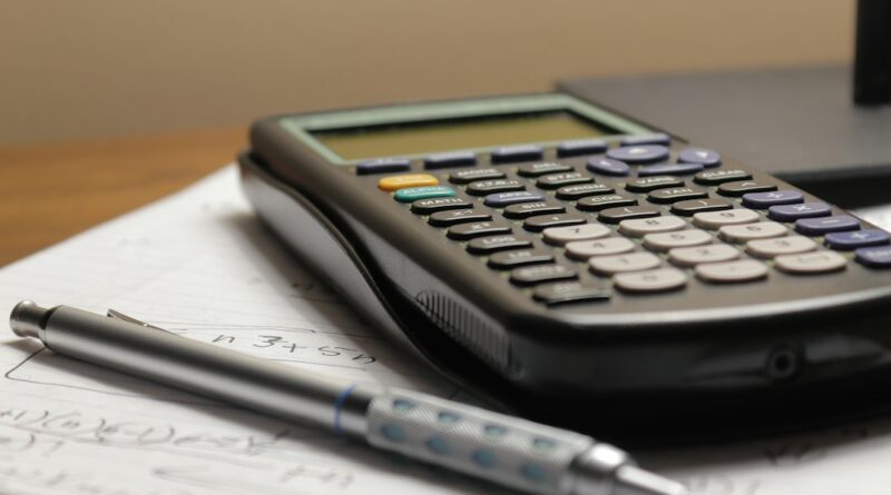 Calculator and pen resting on handwritten notes