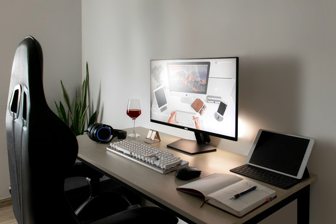 Desk with a monitor, tablet and open notebook
