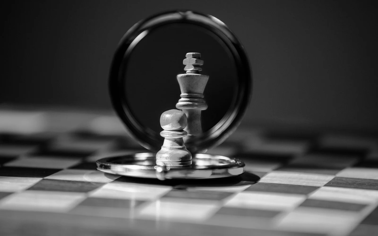 Chess pieces reflected in a round mirror on a chessboard