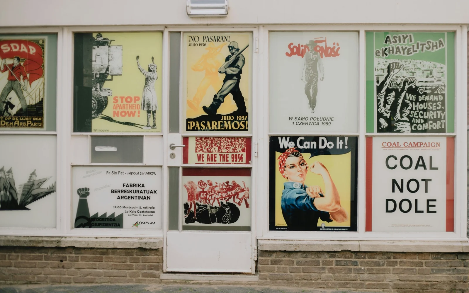 Rows of illustrated posters displayed across shop windows
