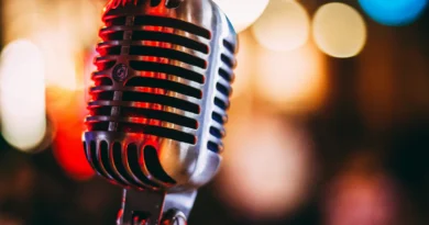 A vintage microphone lit in red against colourful blurred lights